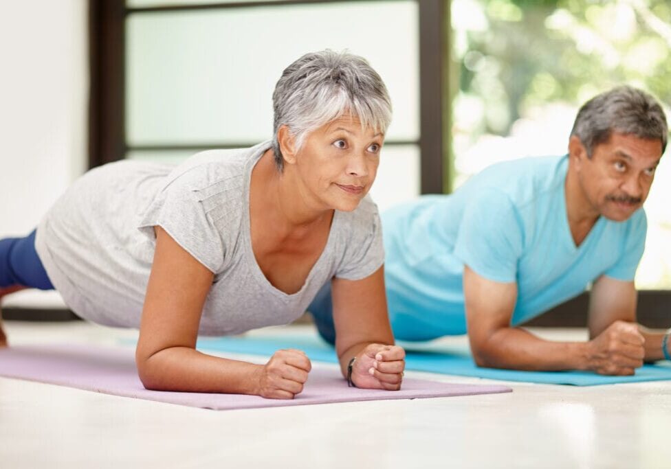 Shot of a mature couple exercising together at home.
